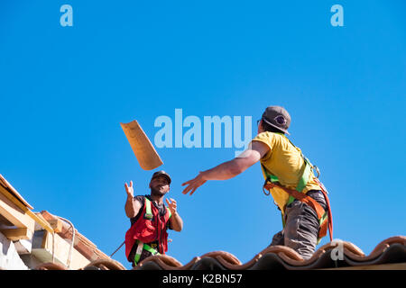 Roofers at work installing tiles on a new home in Provence, France Stock Photo
