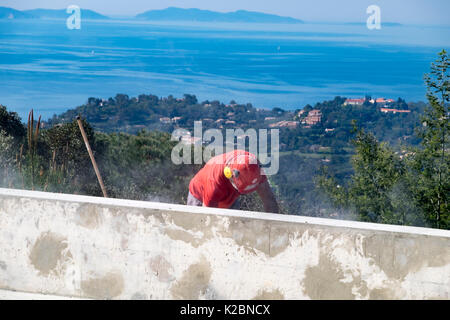 Construction laborer works on the details of building an in ground swimming pool Stock Photo