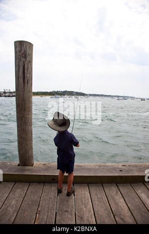 Child fishing from pier, Martha's Vineyard docks and harbour.  Massachusetts, USA, August 2011. Stock Photo