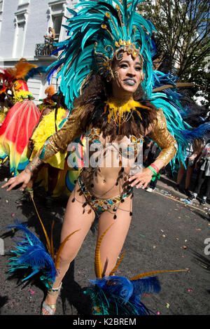Notting Hill Carnival August  2017. A dancer in the parade wearing a feathered head dress and skimpy bikini Stock Photo