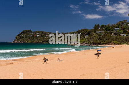 Surfers walking on beach, Australia. November 2012. Stock Photo
