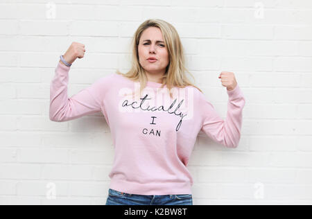 Young blonde woman in her early twenties wearing motivational jumper Stock Photo