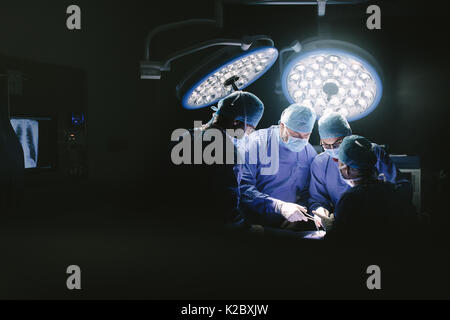 Medical team performing surgery. Group of surgeons in hospital operation theater. Stock Photo