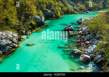 Fisherman fishing in clear blue waters of the Soca river, Soca Valley, Julian Alps, Slovenia, October 2014. Stock Photo