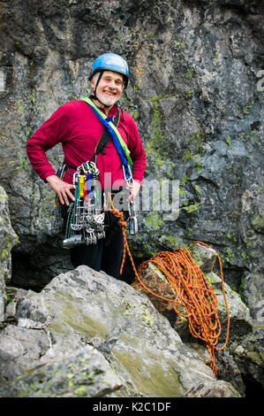 A portrait of a mature man readying himself to go rock climbing. Stock Photo