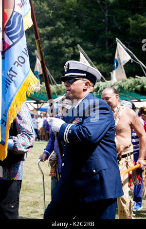 An active duty member of the US military carries his Tribal Flag in a Native ceremony known as Grand Entry. Stock Photo