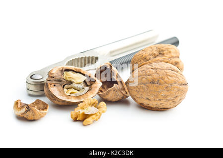 Cracked dried walnuts and nutcracker isolated on white background. Stock Photo