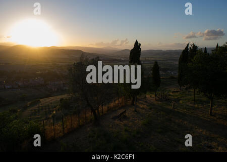 Sunset over the panoramic countryside and farmland, viewed from an Orvieto Wall, Umbria, Italy. Sun setting behind hills, mountains,  on a clear day. Stock Photo