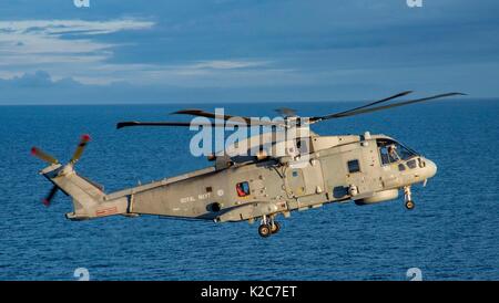 A Royal British Navy Merlin Mk2 helicopter prepares to land on the flight deck of the U.S. Navy Nimitz-class aircraft carrier USS George H.W. Bush during exercise Saxon Warrior August 8, 2017 in the Atlantic Ocean. Stock Photo