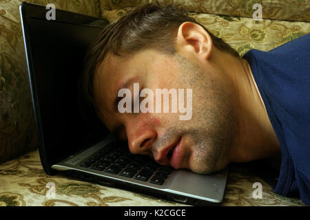 Overworked freelancer sleep on a laptop. Stock Photo