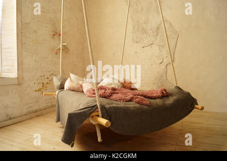 Hanging bed in rural or loft bedroom interior. Stock Photo