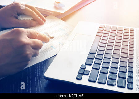 Man in office using laptop and working with business documents. Stock Photo