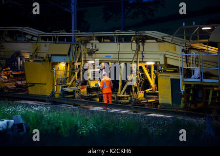 operative working on a Matisa track renewal train relaying track on the West Coast mainline in Lancashire during an overnight engineer's possesion Stock Photo