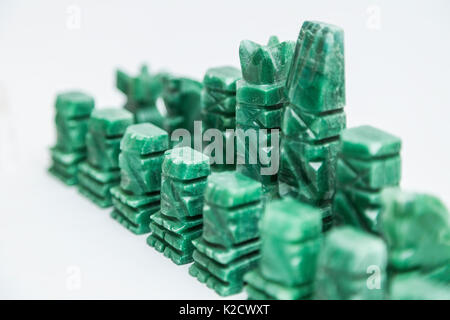 Shiny green stone vintage old handmade chess pieces on white background. Stock Photo
