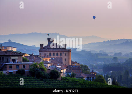 Hot air balloon over the village of Barolo at sunrise, Piedmont, Italy Stock Photo