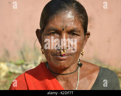 Indian Adivasi woman (Desia Kondh tribe, Kuvi Kondh tribe) with a tattoo on her forehead and gold-and-gemstone nose jewellery poses for the camera. Stock Photo