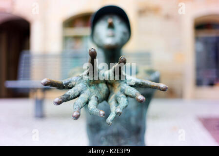 A bronze statue reaching out with grasping fingers and hands. Stock Photo