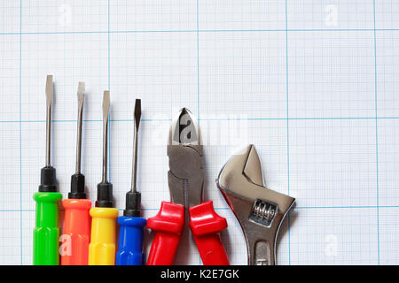 Set of work tools lying on blue graph paper surface Stock Photo