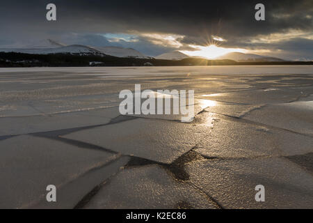Frozen Loch Morlich at sunset with mountains in distance, Cairngorms National Park, Scotland, UK, January 2015. Stock Photo