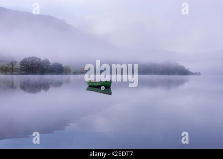 Rowing boat on Ullswater in early morning mist, Lake District, Cumbria, England, UK. November 2015. Stock Photo