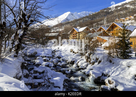 La Valoirette mountain river in winter in front of Valloire ski resort, Savoie in the French Alps. Maurienne Valley, France Stock Photo