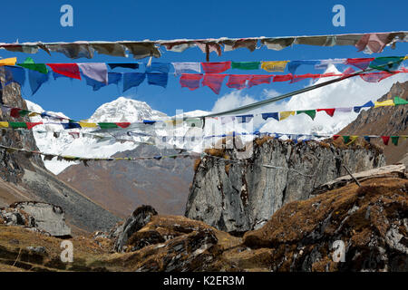 Prayer flags with a view of Jhomolhari 1, Jhomolhari 2 and Jichu Drakye from the false summit on the way to Bhonte La Pass, Jhomolhari Trek. Bhutan, October 2014. Stock Photo