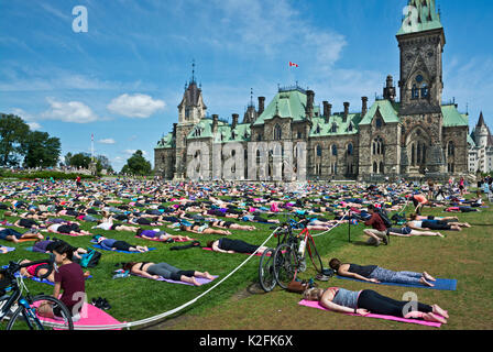 Weekly free group yoga on Parliament Hill in Ottawa, Canada, summer 2017. Canada's Parlament buildings Ottawa. Stock Photo