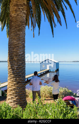 Tourists taking photos of the iconic Crawley Edge Boatshed or Blue Boat House on the Swan River in Matilda Bay, Crawley, Perth, Western Australia