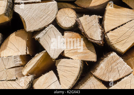 Splitted, dried and stacked firewood, horizontal front view. Stack of weathered, dry wood, a source of energy. Photo. Stock Photo