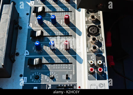 Sunlit dusty sound mixing panel used to control the level of sound during the open air performance. Electronics device for show business. Stock Photo