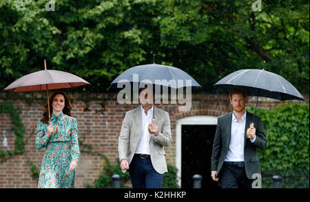 The Duke and Duchess of Cambridge and Prince Harry arrive for a visit to the White Garden in Kensington Palace, London, and to meet with representatives from charities supported by Diana, the Princess of Wales. Stock Photo