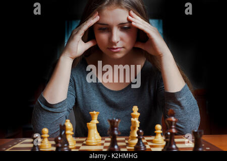 brunette girl thinking a chess move Stock Photo