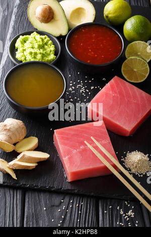Preparation of raw fresh tuna with ingredients close-up on the table. vertical. Stock Photo