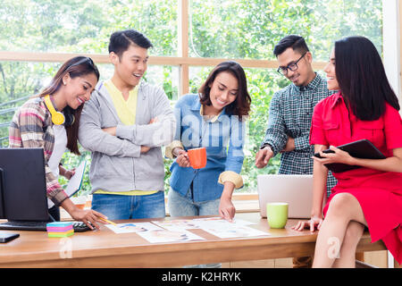 Young team analyzing business information during brainstorming m Stock Photo