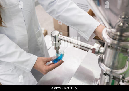 Technician filling container with liquid for laboratory tests du Stock Photo
