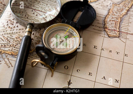 Compass and magnifying glass on old map Stock Photo