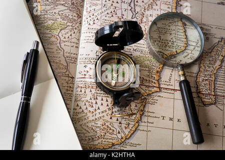 Magnifying glass and compass on old map Stock Photo
