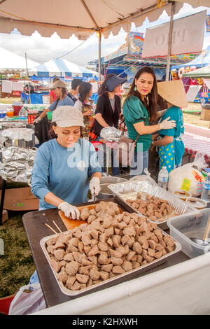 Vietnam American women prepare ethnic Pho Meatballs of pounded beef at a community fair in Costa Mesa, CA. They are served in seasoned beef broth over rice noodles. Stock Photo