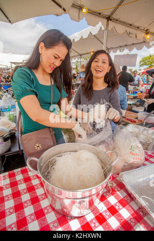 Vietnam American women prepare ethnic rice noodles which are served  served in seasoned beef broth with Pho meatballs of pounded beef at a community fair in Costa Mesa, CA. Stock Photo