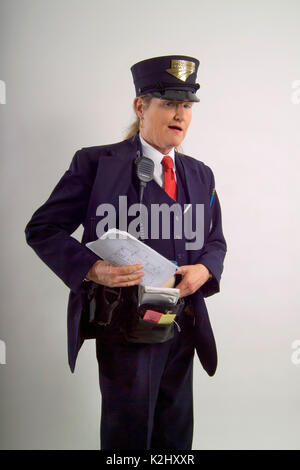 A friendly uniformed woman railroad conductor tucks a schedule sheet into a pouch in Los Angeles, CA. Stock Photo