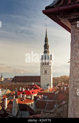 The tower of the St. Nicholas' Church rises in the middle of the medieval buildings of the old town of Tallinn. Stock Photo