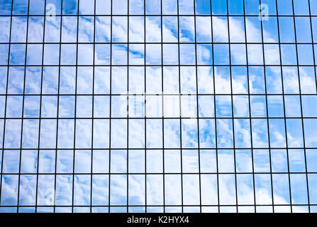 sky and clouds reflected in office glass building facade. modern architecture fragment. Stock Photo