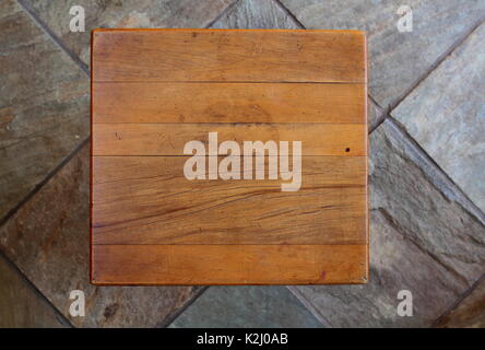 A weather-beaten and worn yellow wood table top viewed from directly above with copy space and a clear background Stock Photo
