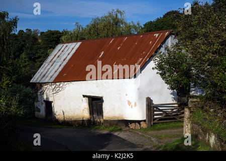 Devon cob barns in rural lane near Dunsford,corrugated tin roofs,lintels,Agricultural range of cladding,winding lanes Stock Photo