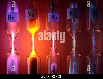 Tubes with inert gases excited with high voltage. From left to right: Helium, Neon, Argon, Krypton and Xenon. Each tube emits a different color and in Stock Photo