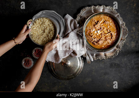 An Indian meat curry with rice, served in silver bowls Stock Photo