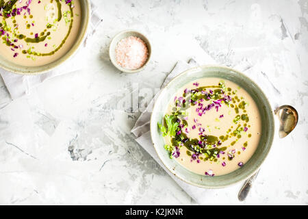 Coconut Red Lentil Purple Cabbage Soup with Cilantro Oil.  Photographed on a white/grey plaster background. Stock Photo