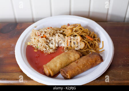 Heavy meal of spring rolls, shrimp lo mein, fried rice and sweet and sour sauce Stock Photo