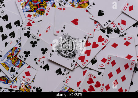a deck of cards in a messy pile showing the Ace of Spades on top of the pile. Stock Photo