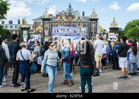 Well-wishers gather outside the gates of Kensington Palace to commemorate and pay tribute to Princess Diana, twenty years after her death. Stock Photo